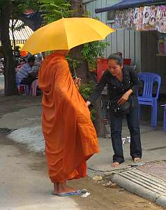 Woman giving alms to a monk