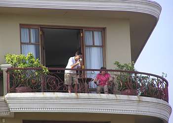 A young tourist couple watch from a balcony