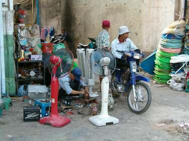 Repairing fans on the sidewalk