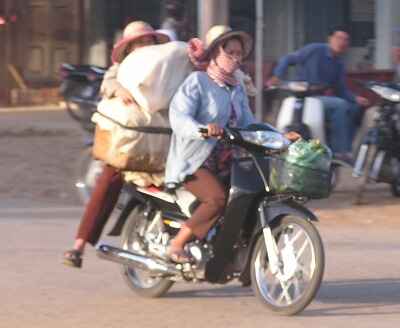 A Cambodian girl is sqeezed between a driver and a passenger of an  overloaded motorbike taxi in the capital Phnom Penh, Tuesday, April 4,  2006. Overloaded motorcycles and cars are a common