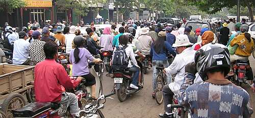 A Cambodian girl is sqeezed between a driver and a passenger of an  overloaded motorbike taxi in the capital Phnom Penh, Tuesday, April 4,  2006. Overloaded motorcycles and cars are a common