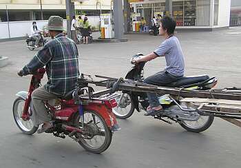 Motorcycle pulling a wagonload of steel