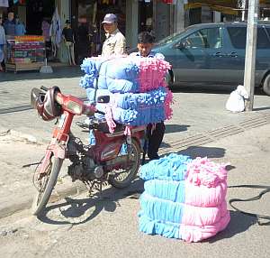 Loading lots of T-shirts on a motorbike