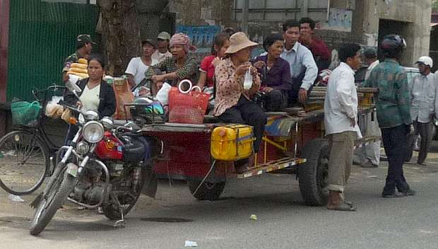 A Cambodian girl is sqeezed between a driver and a passenger of an  overloaded motorbike taxi in the capital Phnom Penh, Tuesday, April 4,  2006. Overloaded motorcycles and cars are a common