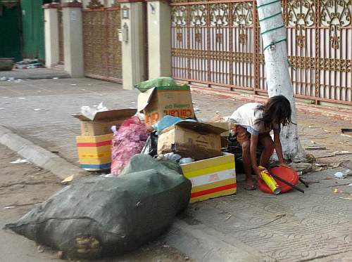 Little girl scavenging trash