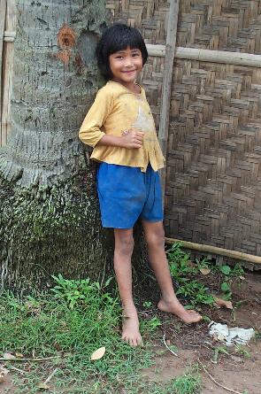 Little girl leaning on a tree