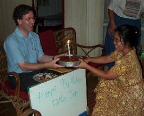 Dr. Frans Lion accepting a birthday cake for Jim Noonan