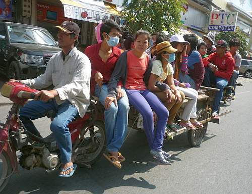 A Cambodian girl is sqeezed between a driver and a passenger of an  overloaded motorbike taxi in the capital Phnom Penh, Tuesday, April 4,  2006. Overloaded motorcycles and cars are a common