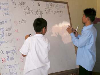 Student at the board with the teacher