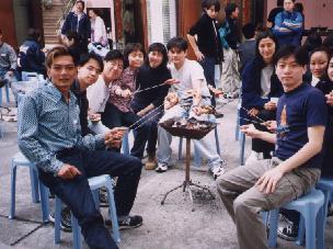 CMS past pupils around a BBQ grill