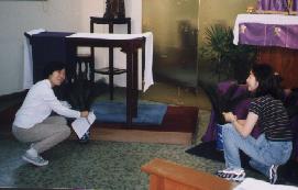 Two volunteers prepare the chapel