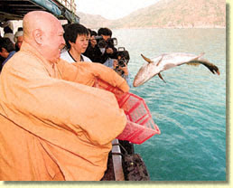 Monk Releasing Fish into Sea