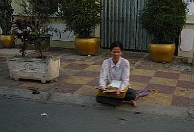 Woman sitting on edge of the street